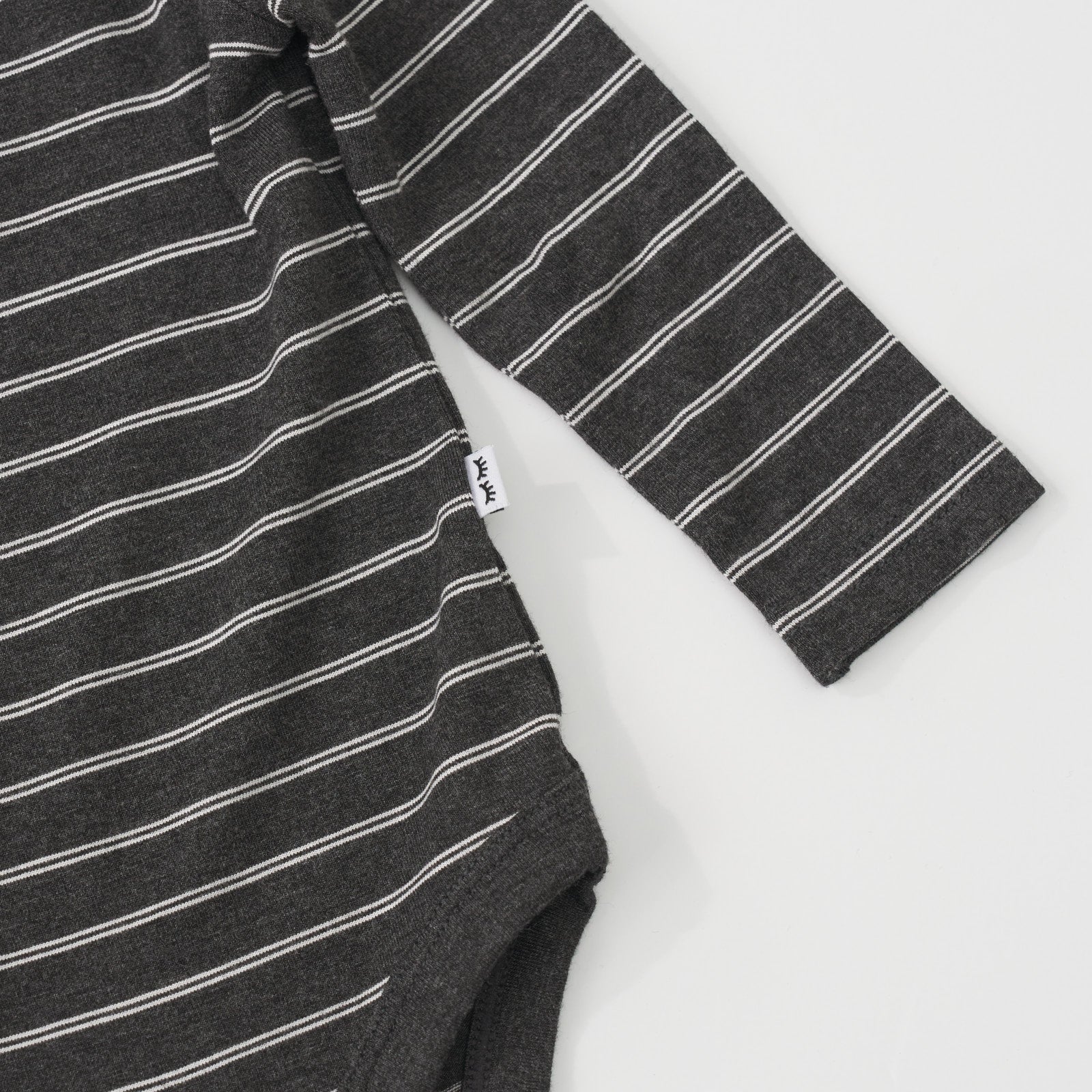 Close-up view of the white striped pattern on a Heather Black Stripes long sleeve baby bodysuit