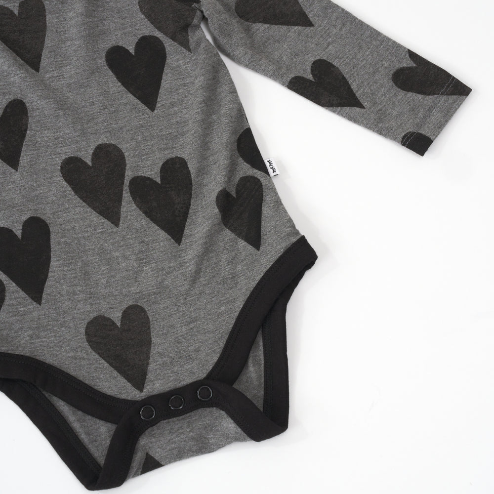 close up view of the button snap closure on a heather hearts bodysuit