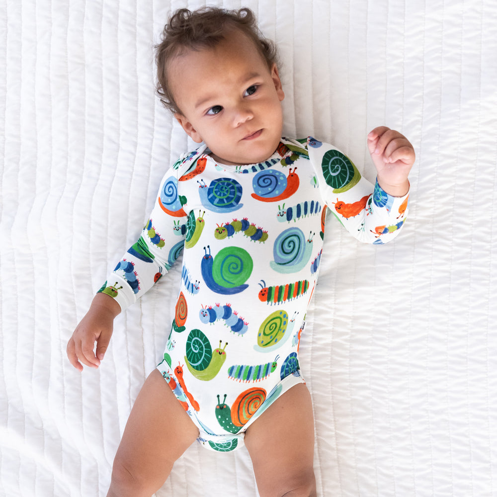 Top view image of baby laying down while wearing the Inchin' Along Bodysuit