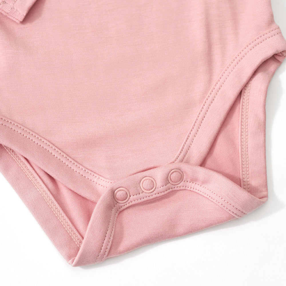 Close up image of the snap detail on the Mauve Blush Bodysuit