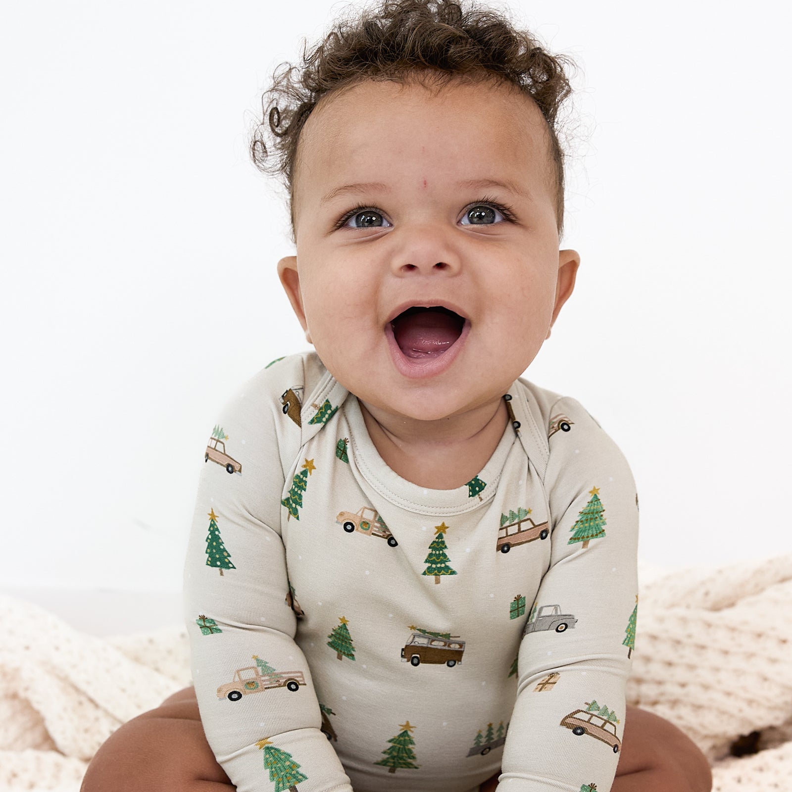 Alternate image of a child sitting on a blanket wearing a Tree Traffic Bodysuit