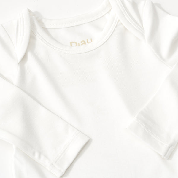 Close up flat lay image of the shoulder detail on the Soft White Bodysuit