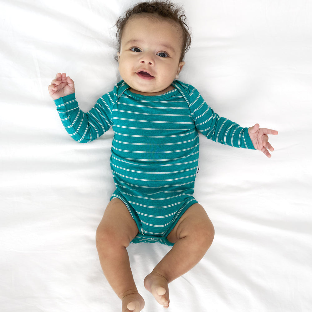 Top view image of baby laying down while in the Glacier Stripes Bodysuit