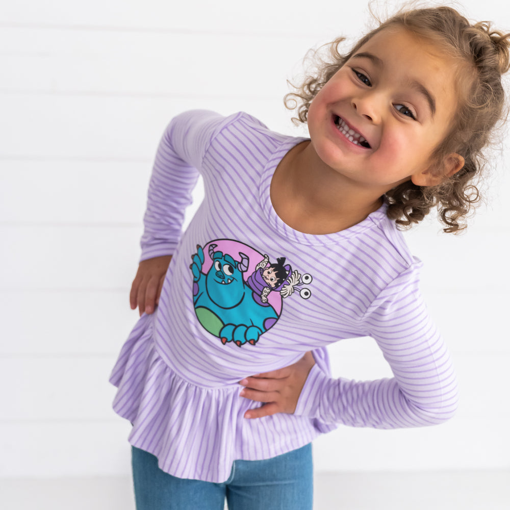 Girl posing while wearing the Disney Monsters, Inc. Peplum Tee