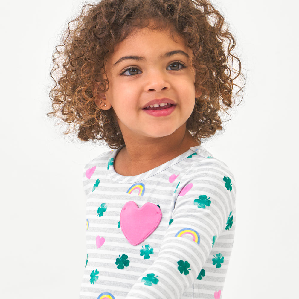 Click to see full screen - Close up image of a child wearing a Lucky in Love pocket peplum tee