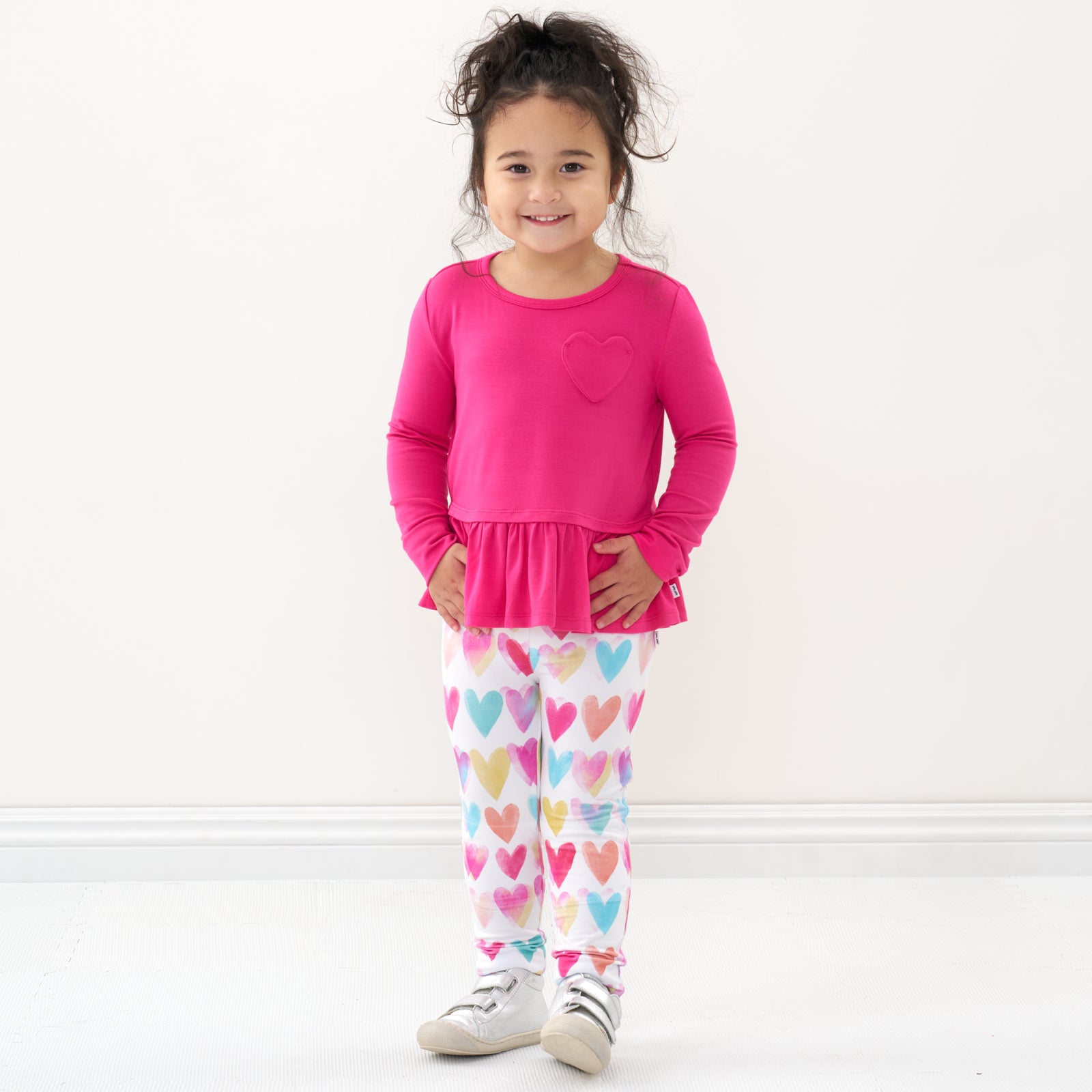 Child wearing a Pink Punch peplum tee and coordinating leggings