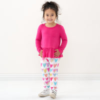 Child wearing a Pink Punch peplum tee and coordinating leggings