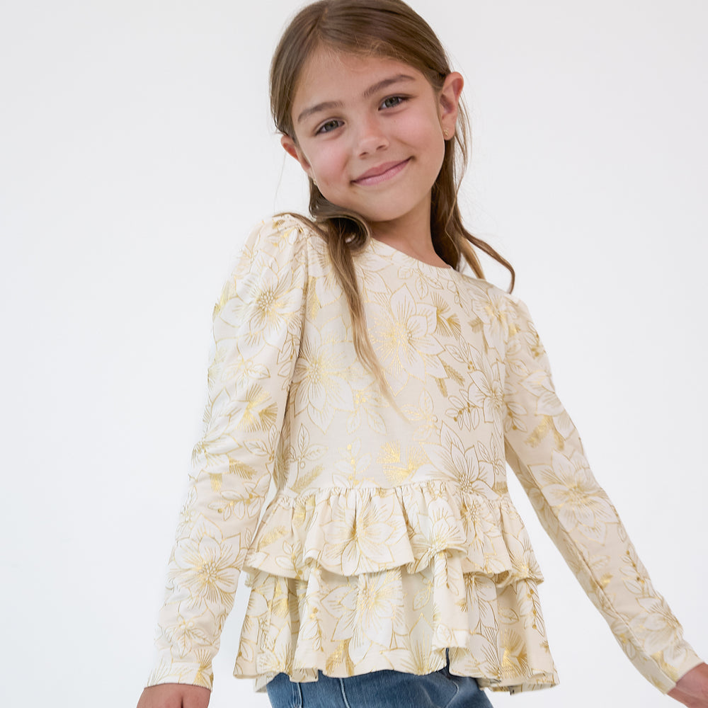 Close up image of a child wearing a Golden Blooms Tiered Peplum Top