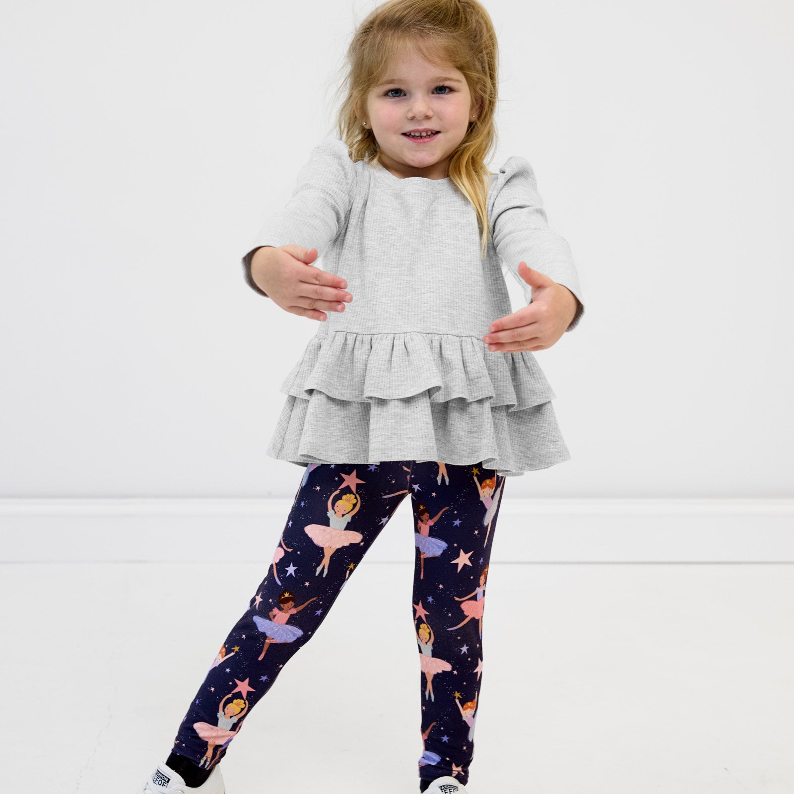 Girl posing in the Light Heather Gray Ribbed Tiered Peplum Top and Twilight Ballet Leggings