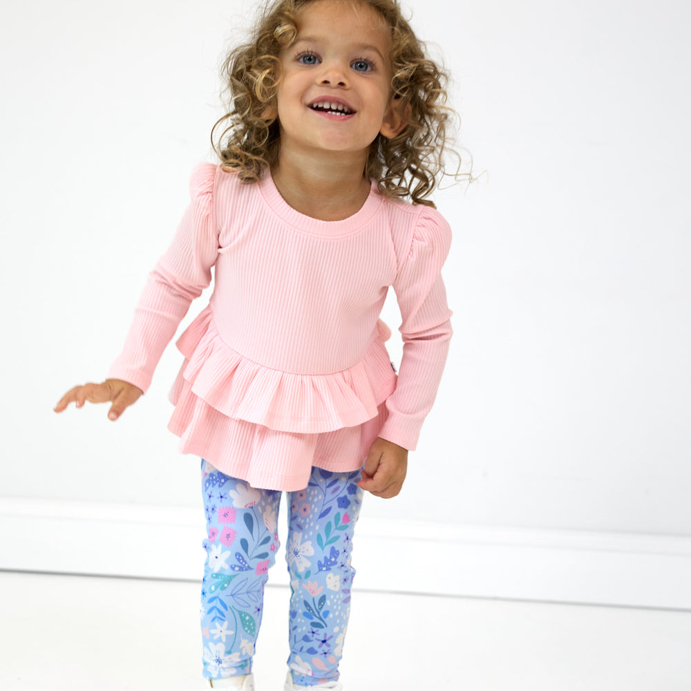 Girl posing while wearing the Prima Pink Ribbed Tiered Peplum Top and Magical Meadows Leggings