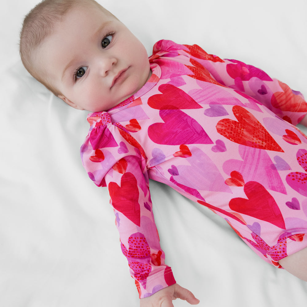 Close up of an infant lying on a blanket wearing a Pink Hearts & Crafts Puff Sleeve Bodysuit