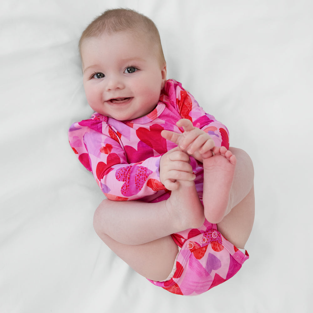 Infant lying on a blanket wearing a Pink Hearts & Crafts Puff Sleeve Bodysuit