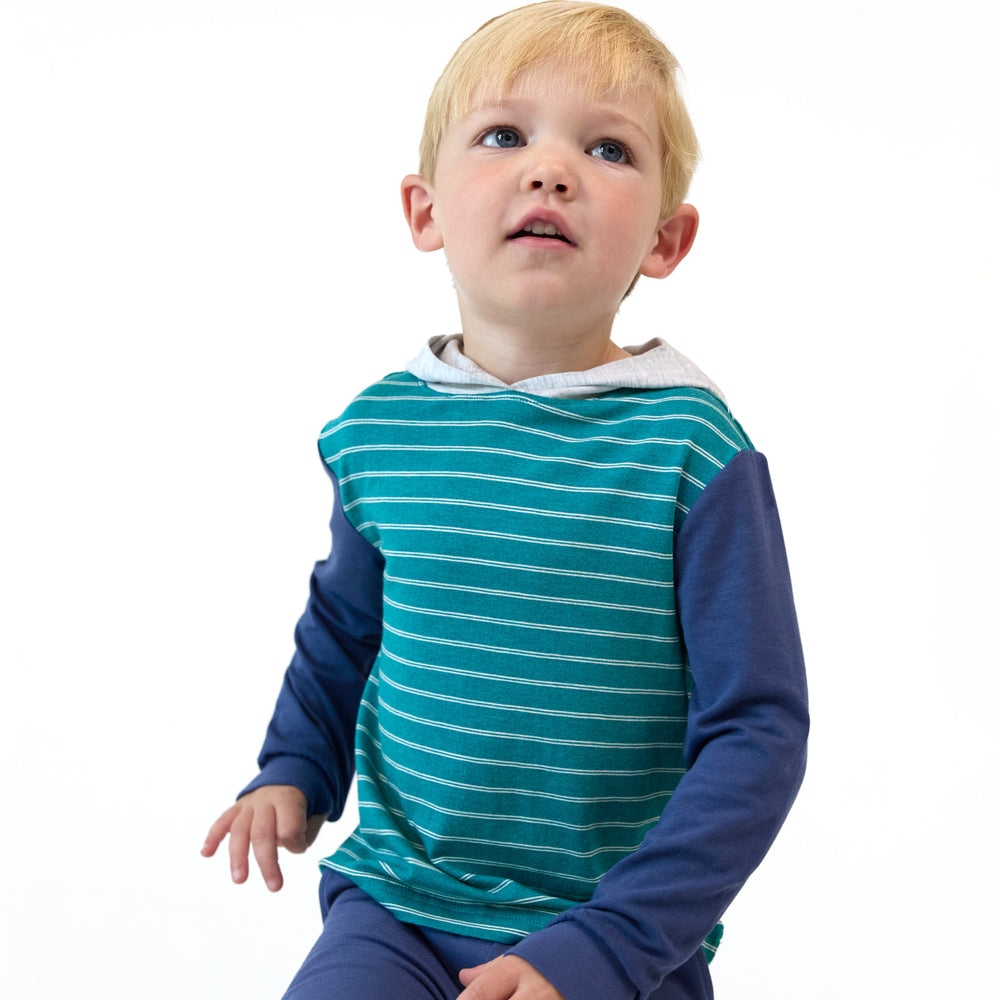 Boy posing while wearing the Glacier Stripes Relaxed Hooded Tee