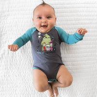 Top view image of baby laying down while in the Disney Jack & Crew Graphic Raglan Bodysuit