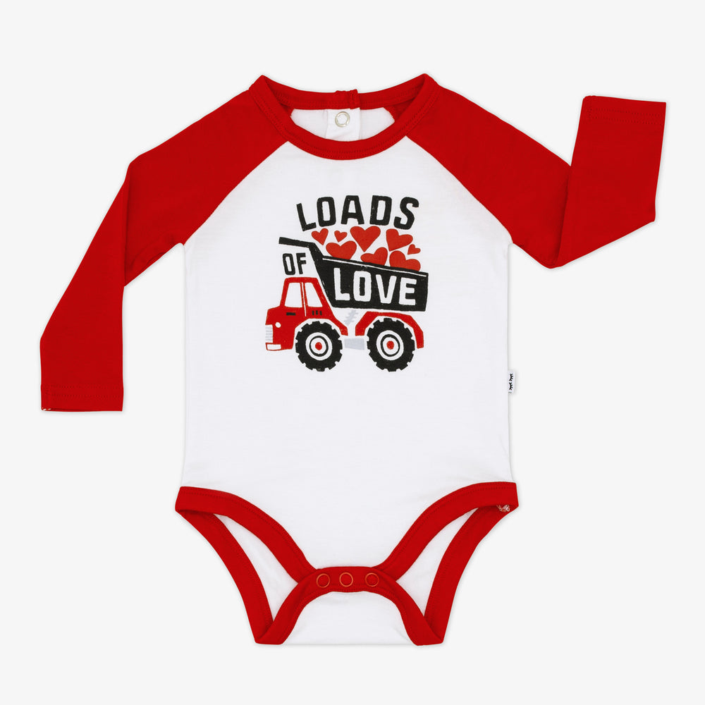 Flat lay of a Loads of Love Raglan Bodysuit featuring red long sleeves and a white body with a graphic of a truck full of hearts and the phrase "loads of love" and a button snap closure