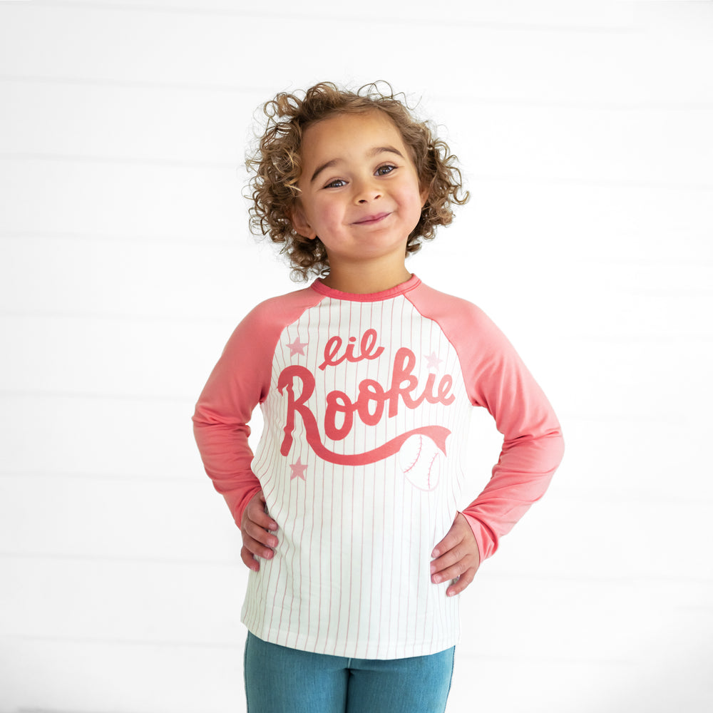 Close up image of a child wearing a Pink Lil Rookie Raglan Tee and Light Blue Denim Jegging