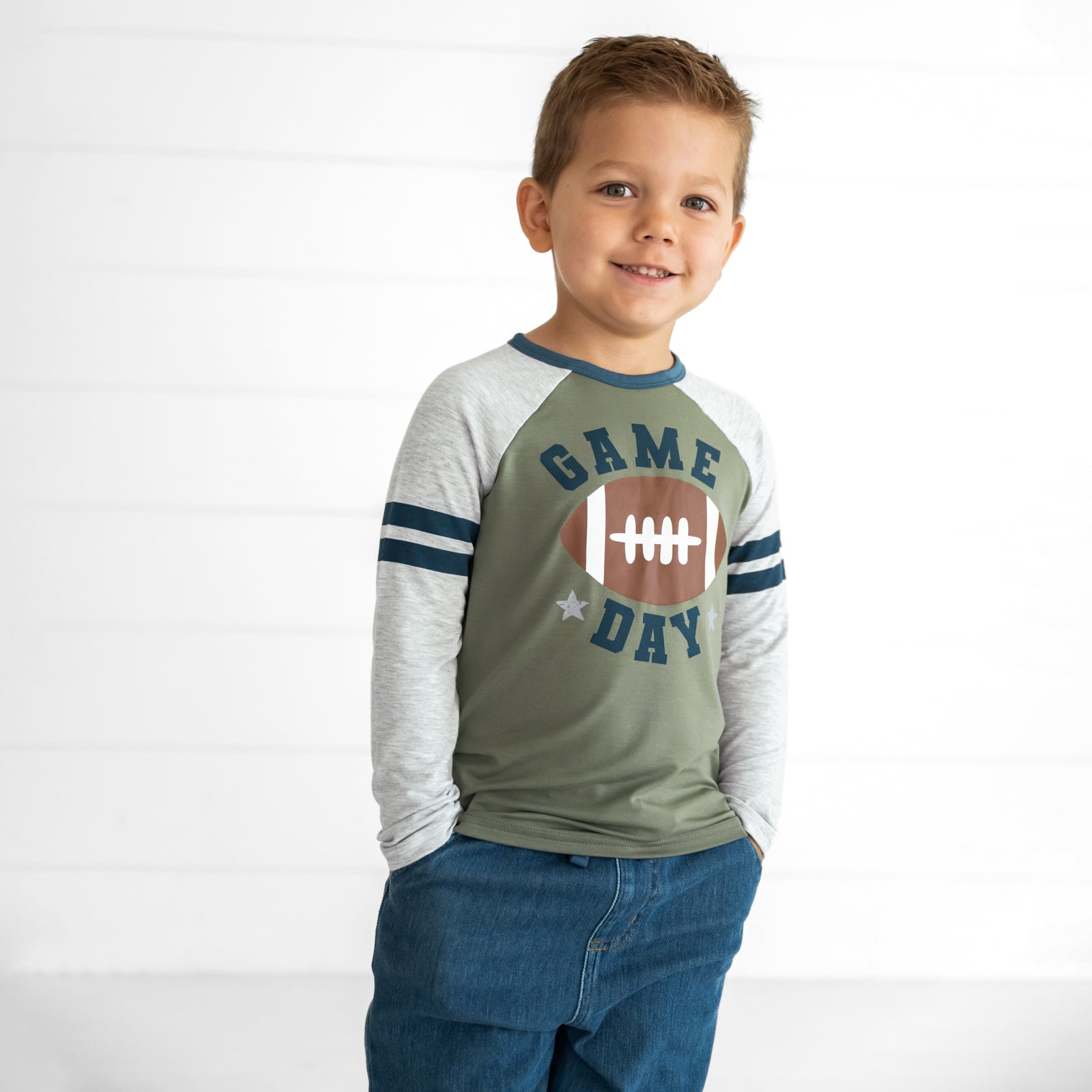 Close up image of a child wearing a Game Day Raglan Tee and Midwash Blue Denim Jogger