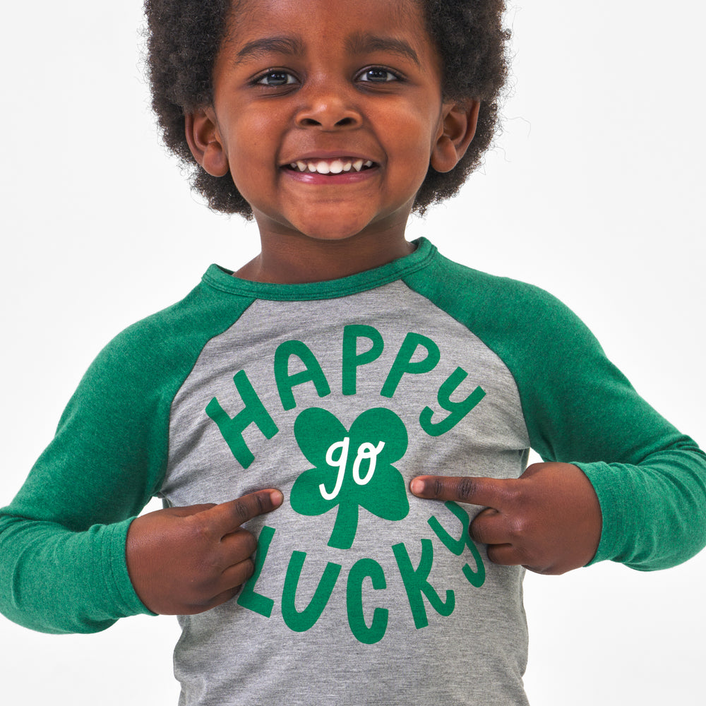 Click to see full screen - Close up image of a child wearing a Happy Go Lucky raglan tee