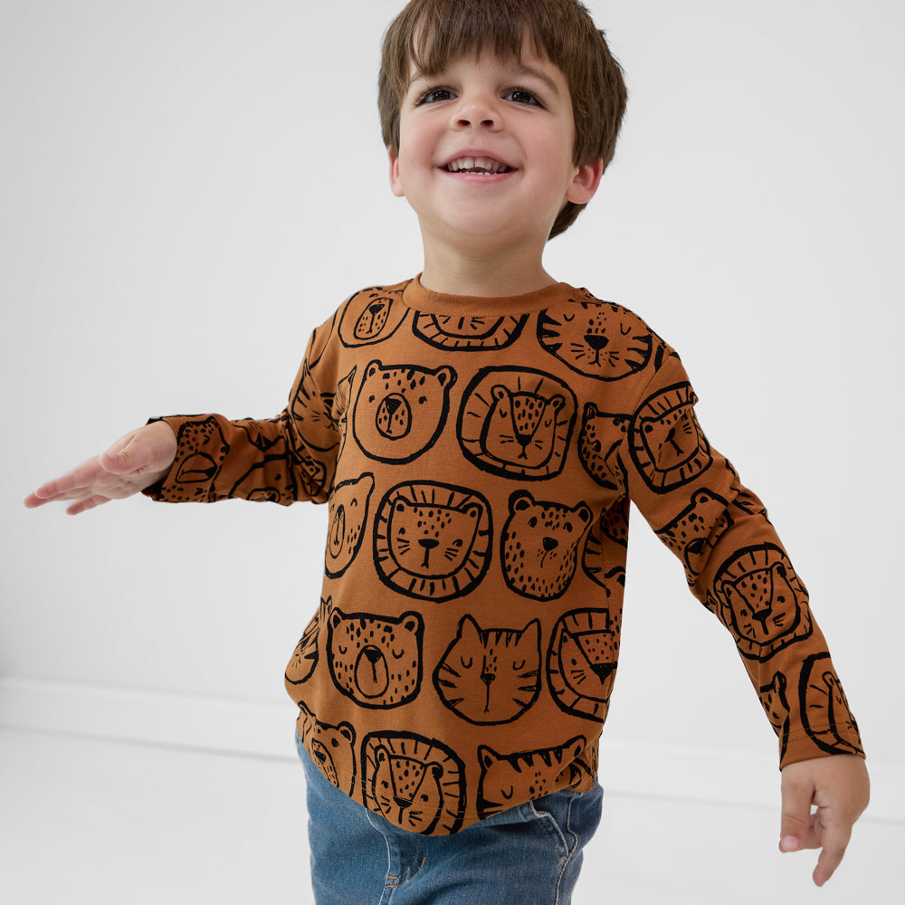 Child wearing an Amber Lions, Tigers & Bears Relaxed Tee with black animal illustrations, paired with denim joggers.