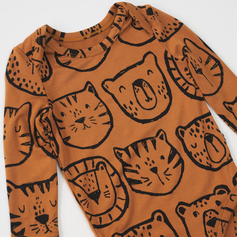 Close-up view of the lap shoulders on an Amber Lions, Tigers & Bears baby bodysuit with long sleeves and black illustrations.