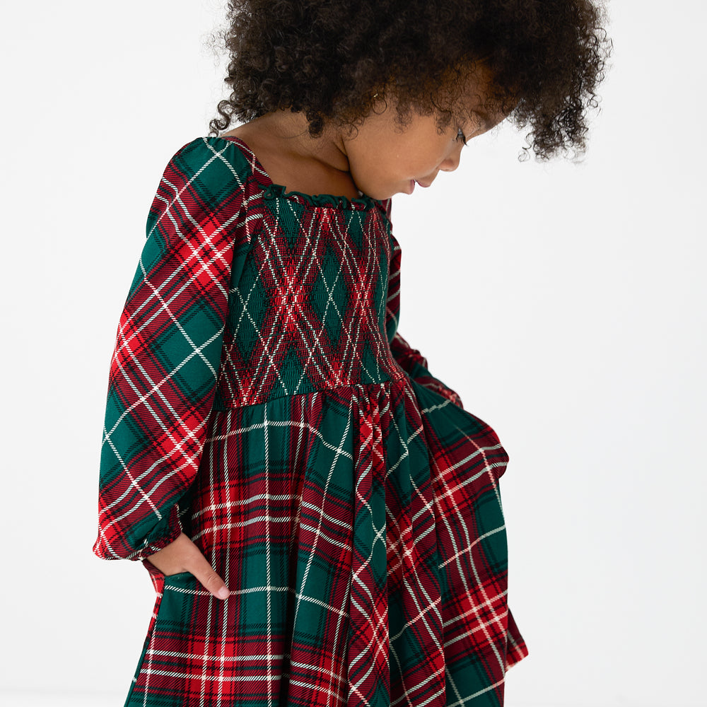 Alternate close up image of a child wearing a Fireside Plaid Smocked Dress