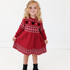 Image of a child wearing a Vintage Mickey Fair Isle Sweater Dress and holding out the sides