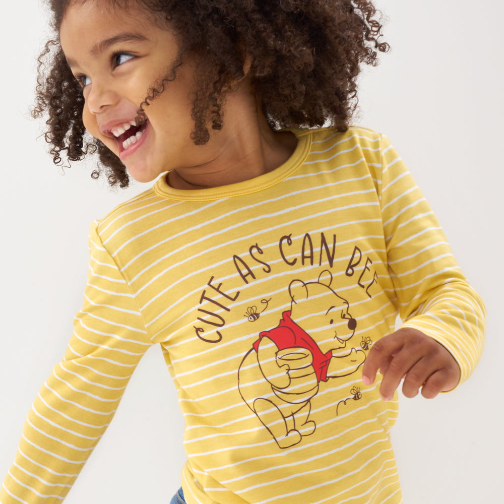 Click to see full screen - Close up image of a child wearing a Disney Winnie the Pooh graphic tee