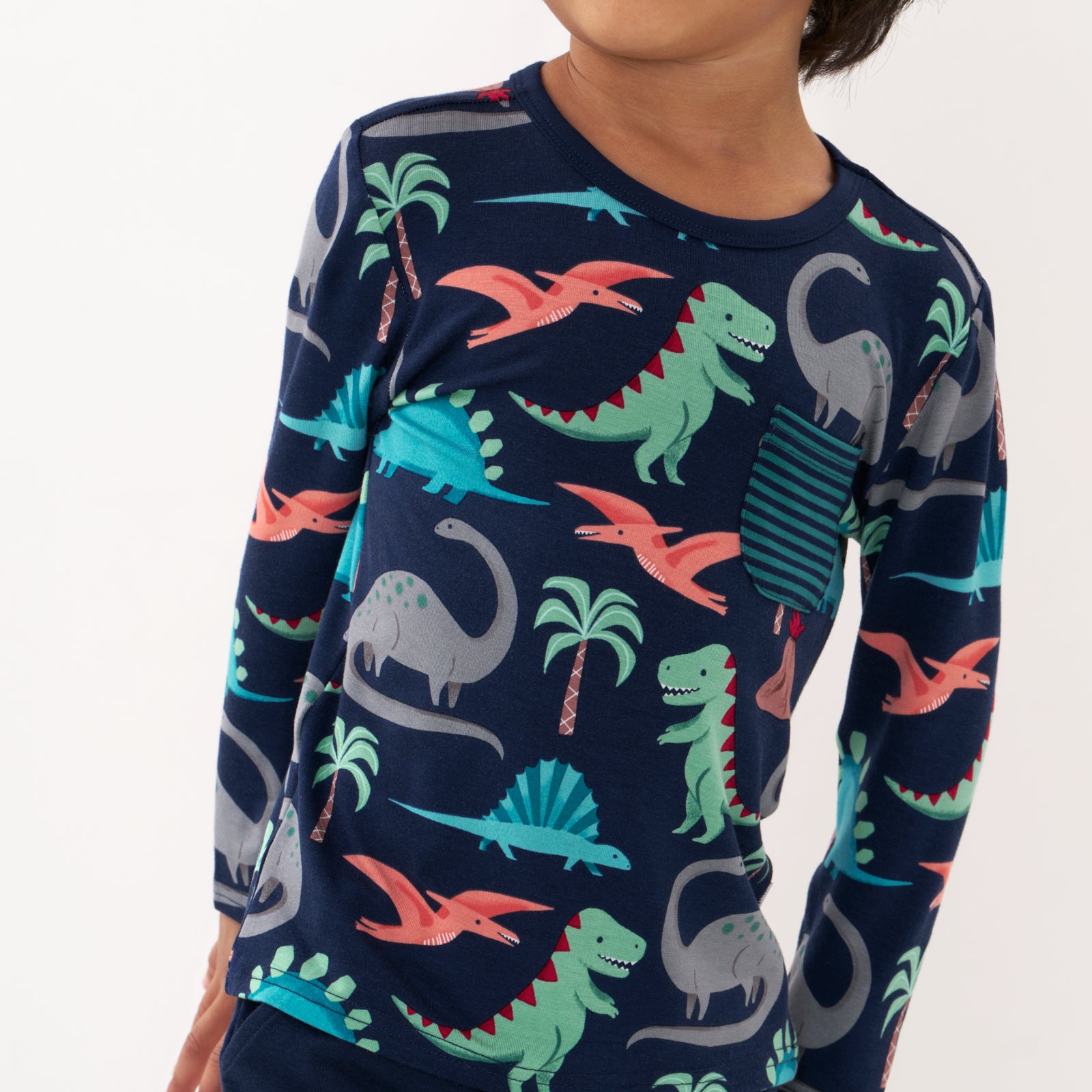 Close up image of a child wearing a Blue Prehistoric Pals pocket tee