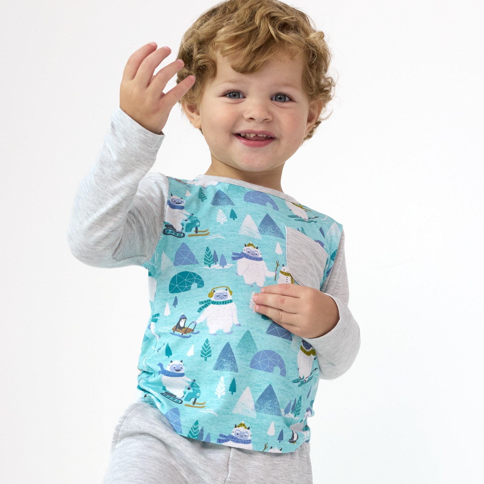 Smiling child posing while wearing the Yeti Snow Day Raglan Pocket Tee