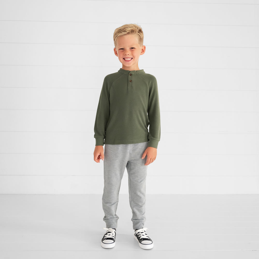 Image of a child wearing an Olive Waffle Henley Tee and Light Heather Gray Jogger