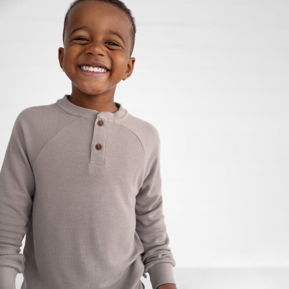 Close up image of a child wearing a Pebble Waffle Henley Tee