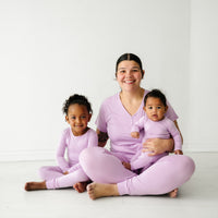 Family of three wearing matching Light Orchard pajama sets. mom is wearing women's Light Orchard women's pajama top and matching women's pj pants. Kids are wearing matching Light Orchard two piece and zippy styles