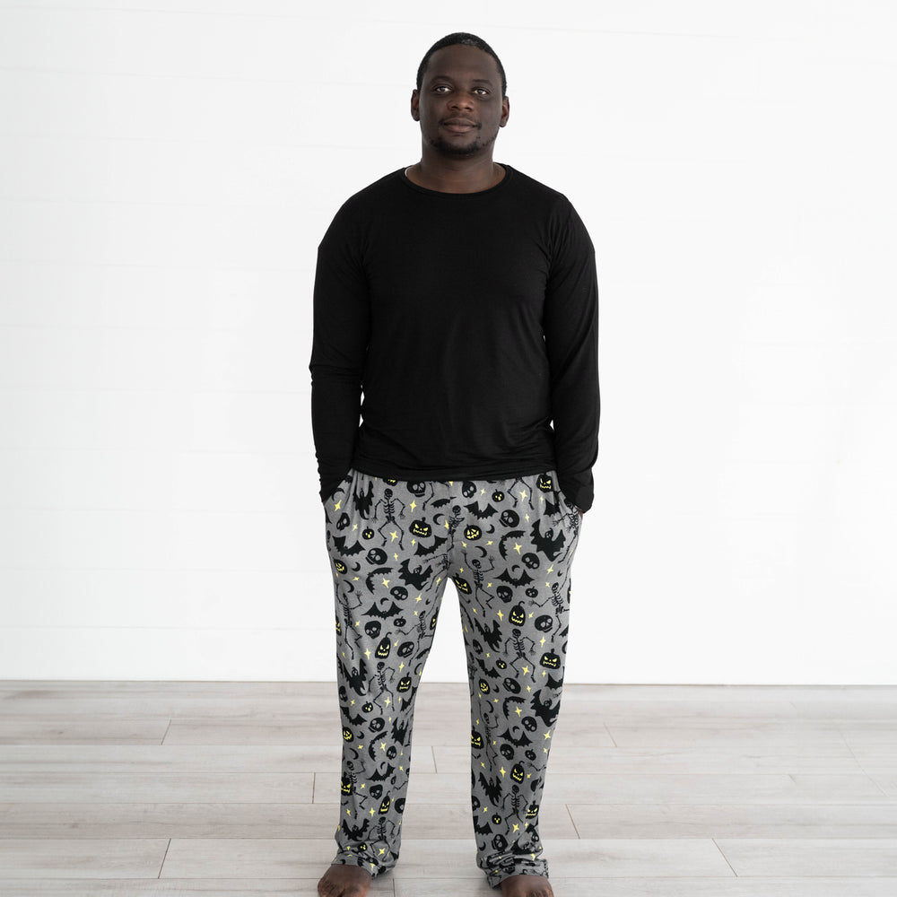 Male model wearing the Gray Glowing Ghouls Men's Pajama Pants & Men's Black Pajama Top