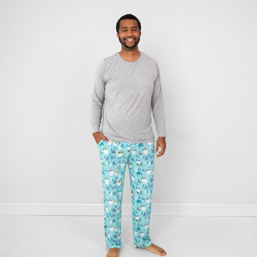 Image of a man wearing a heather gray men's pj top and men's Yeti Snow Day pj pants