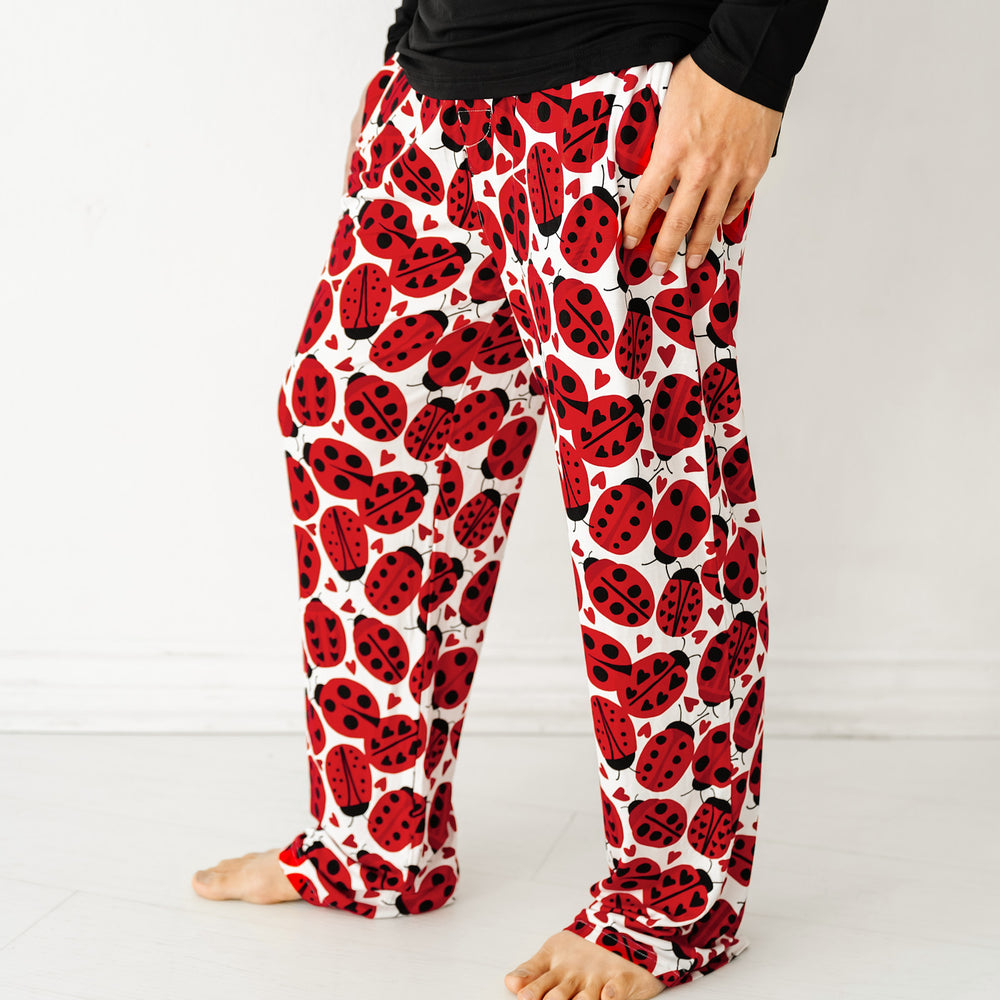 Close up side view image of a man wearing Love Bug printed men's pajama pants and coordinating pajama top