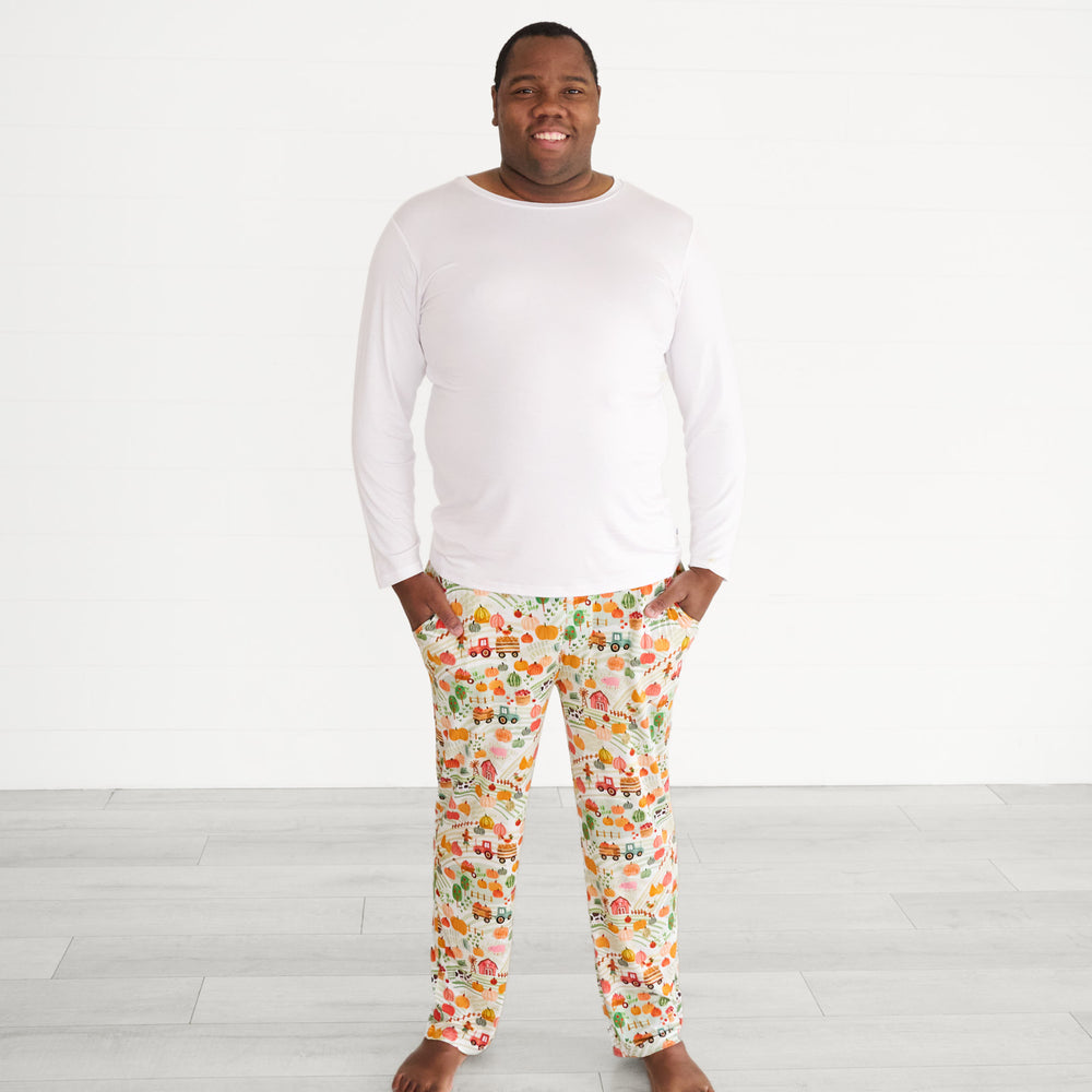 Close up image of a man wearing Happy Harvest men's pj pants paired with a men's Bright White pj top