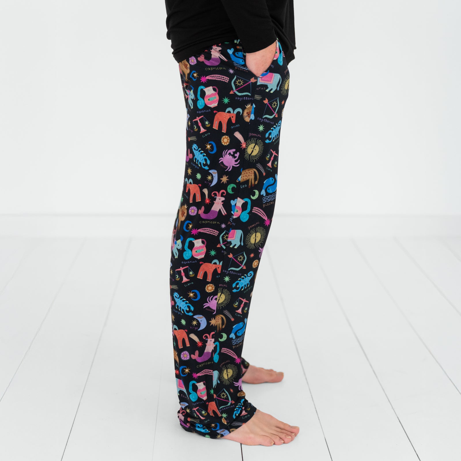 Close up image of a man wearing Star Signs men's pj pants. Side view.