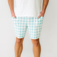 Close up image of a man wearing men's Aqua Gingham pajama shorts