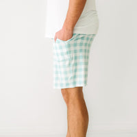 Close up profile image of a man wearing men's Aqua Gingham pajama shorts