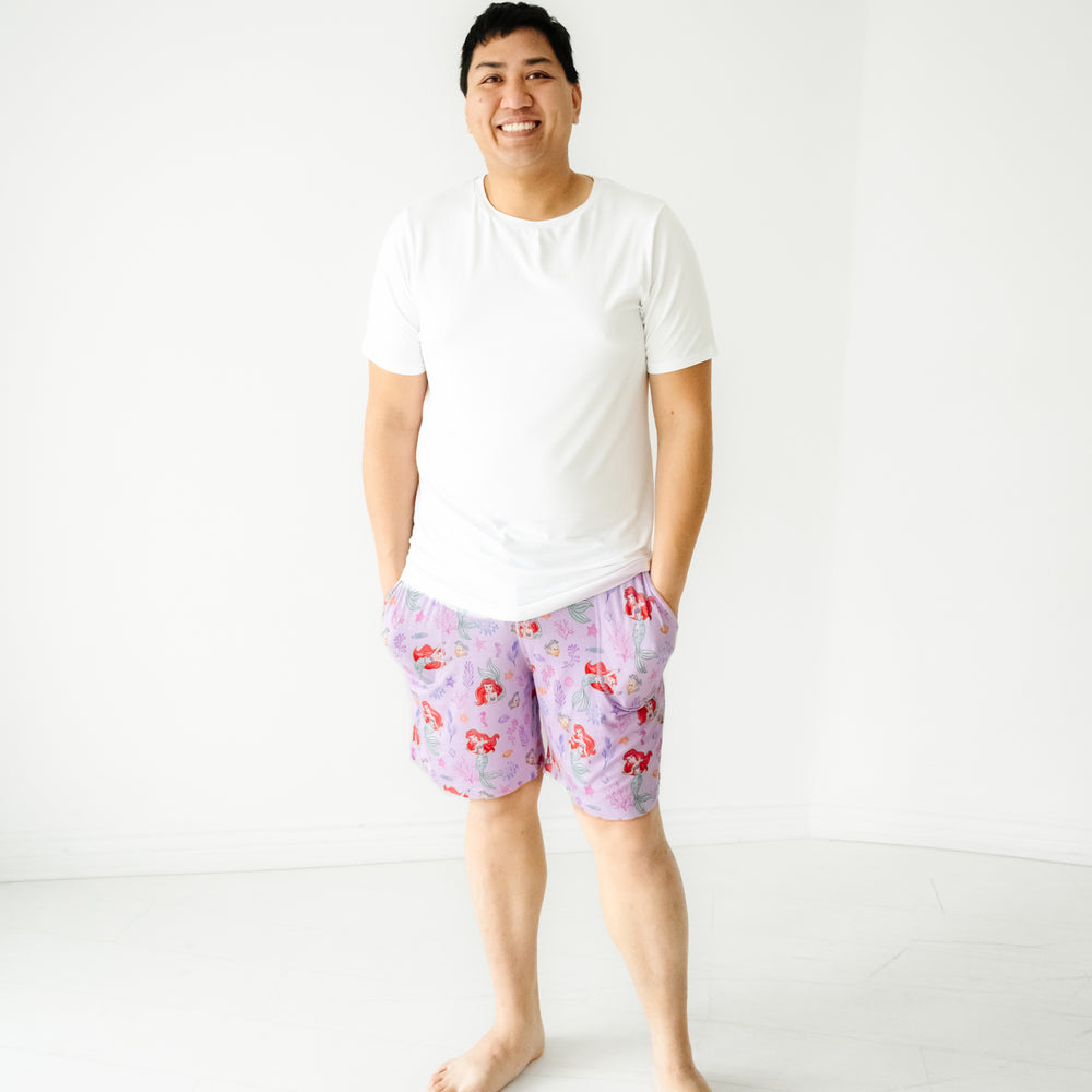 Man wearing Disney Part of Her World men's pajama shorts paired with a men's Bright White short sleeve pajama top