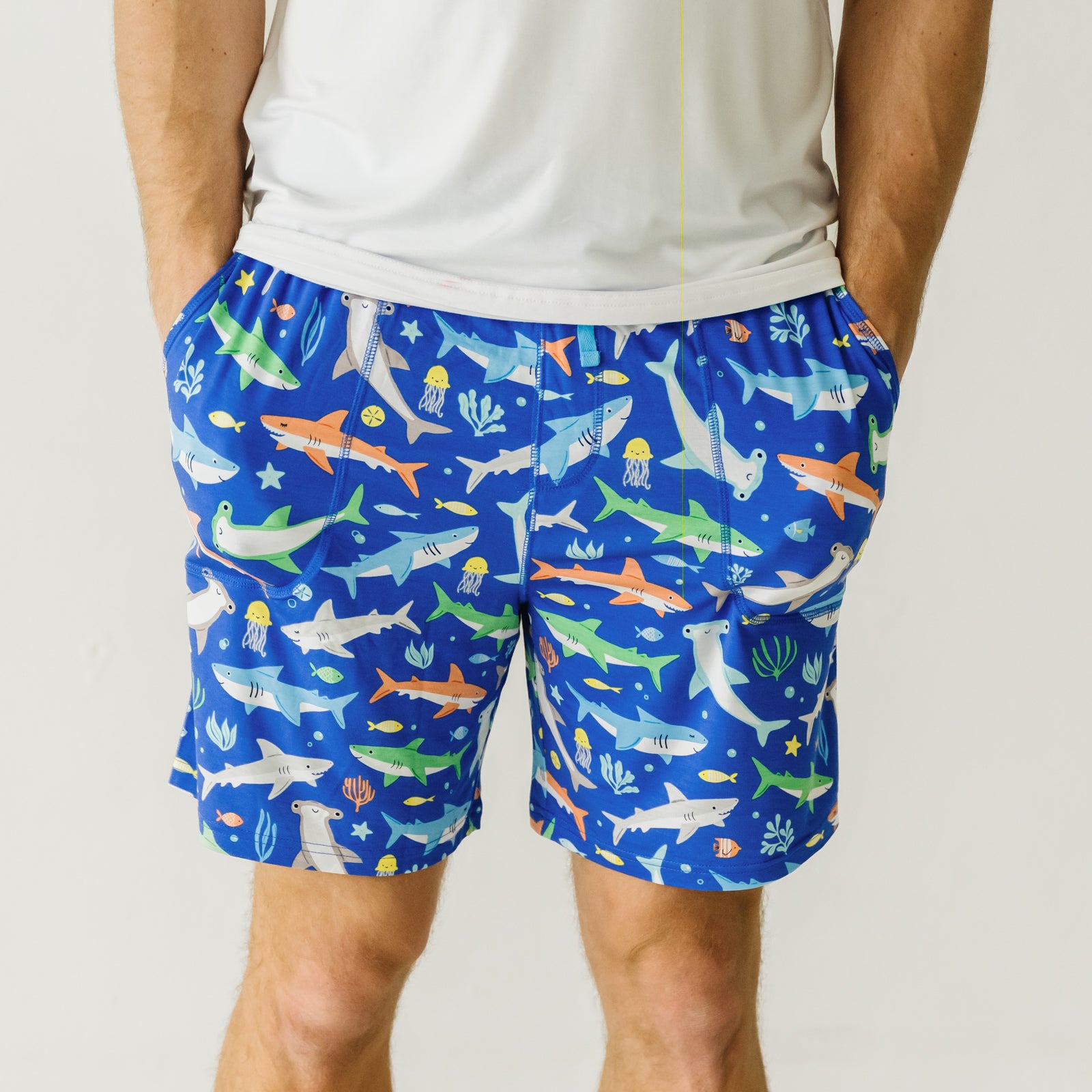 Close up image of a man wearing Rad Reef men's pajama shorts and coordinating pajama top