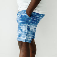 Close up side view image of a man wearing Blue Tie Dye Dreams men's pajama shorts and coordinating pajama top