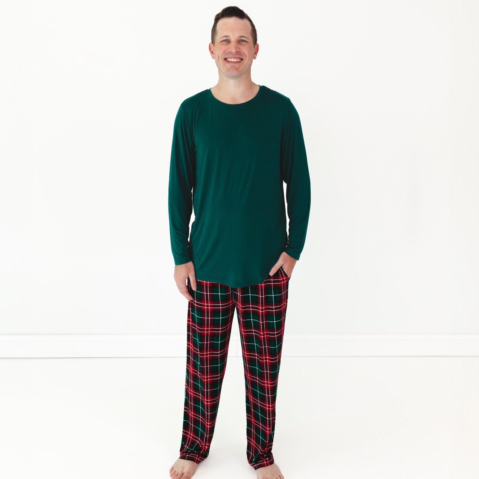 Smiling male model wearing the Emerald Men's Pajama Top and Fireside Plaid Men's Pajama Pants 