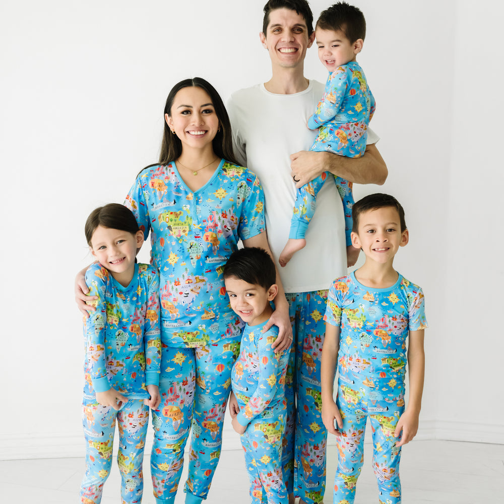 Family of six wearing matching Around the World pjs in men's, women's, and children's styles. Dad is pairing his Around the World printed pants with a solid bright white men's short sleeve pj top