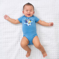 Child laying on a blanket wearing a Bluey graphic bodysuit