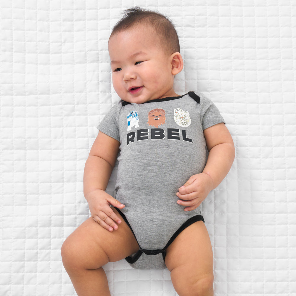 Child laying on a blanket wearing a Rebel graphic bodysuit