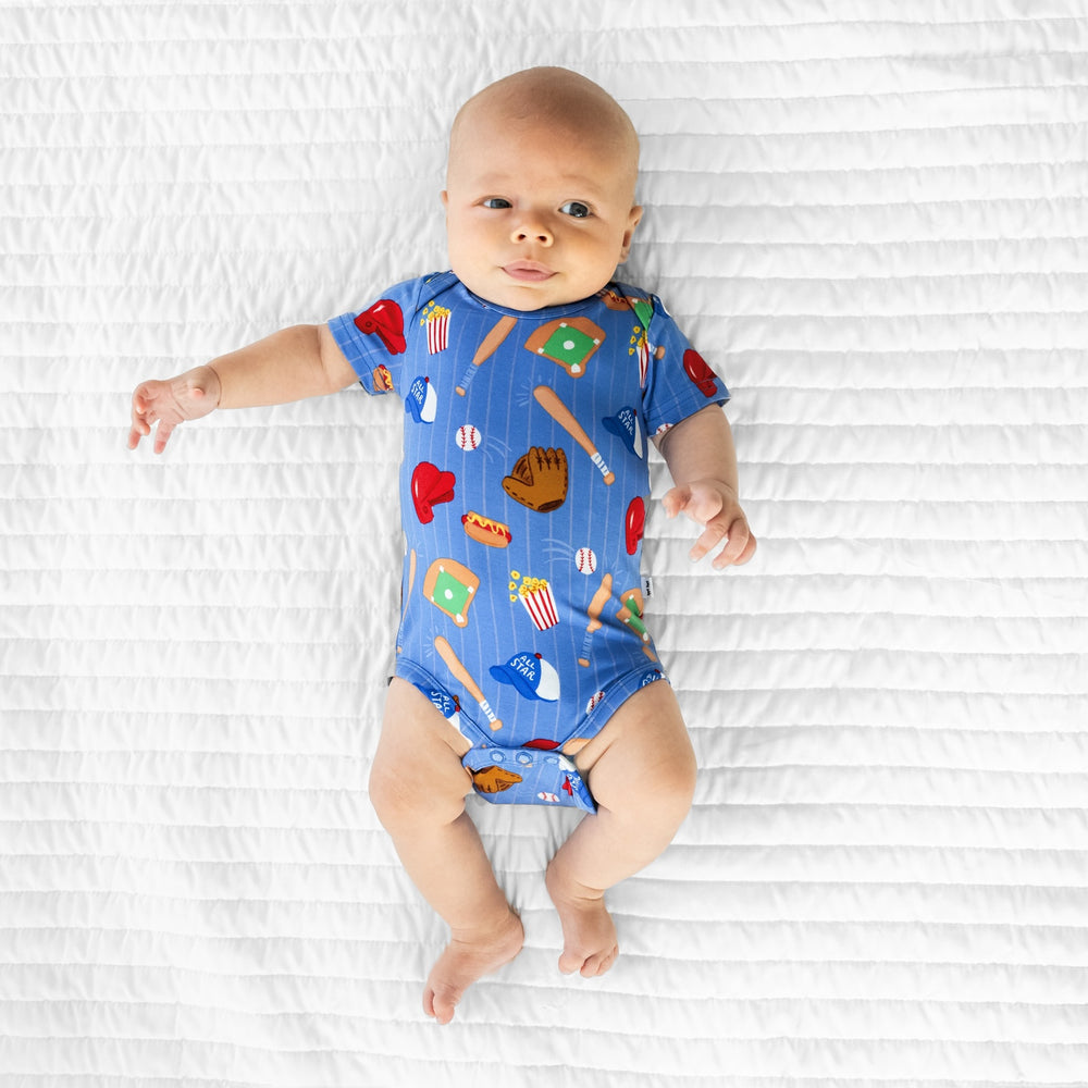 Image of an infant laying on a blanket wearing a Blue All Stars Bodysuit