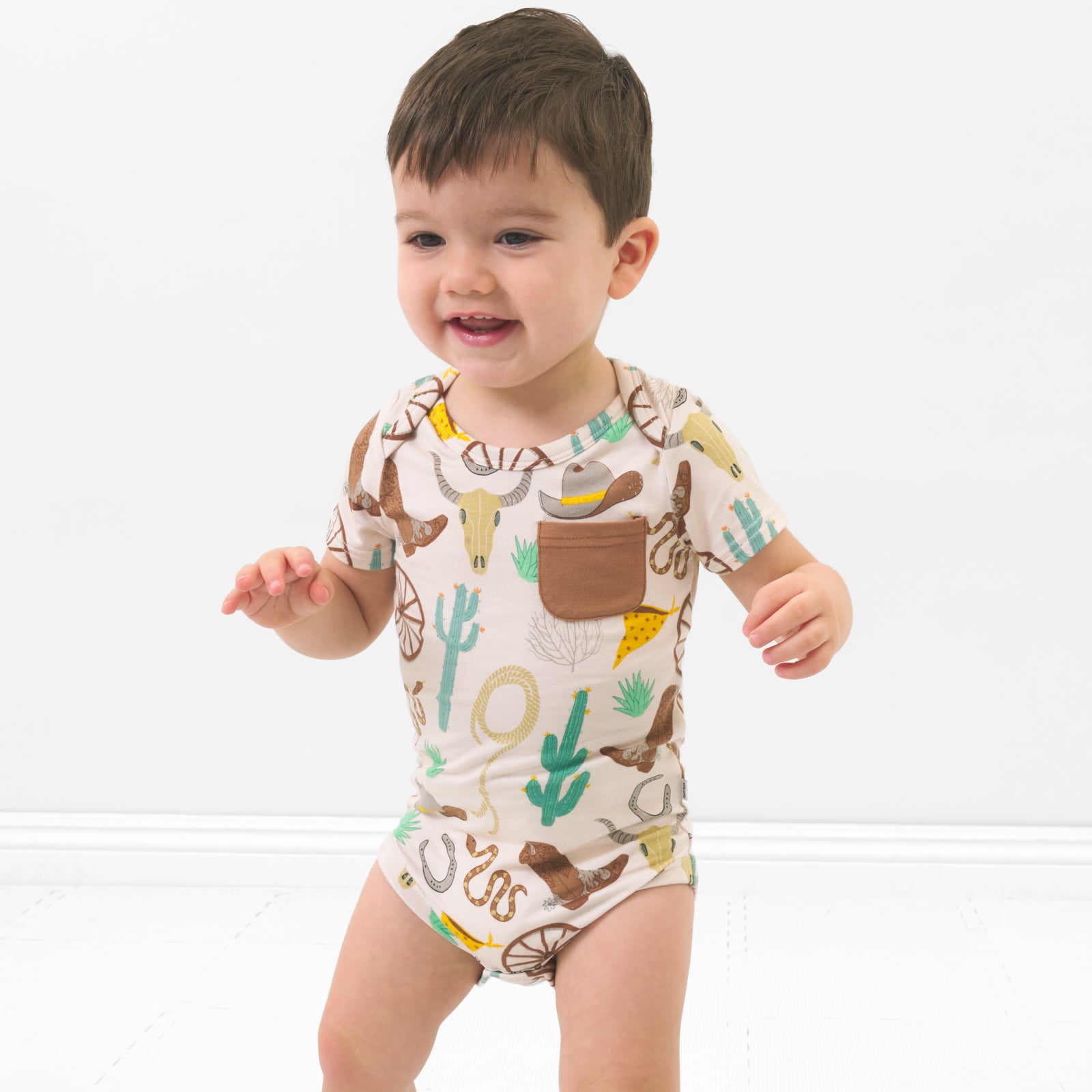 Child wearing a Caramel Ready to Rodeo Pocket Bodysuit