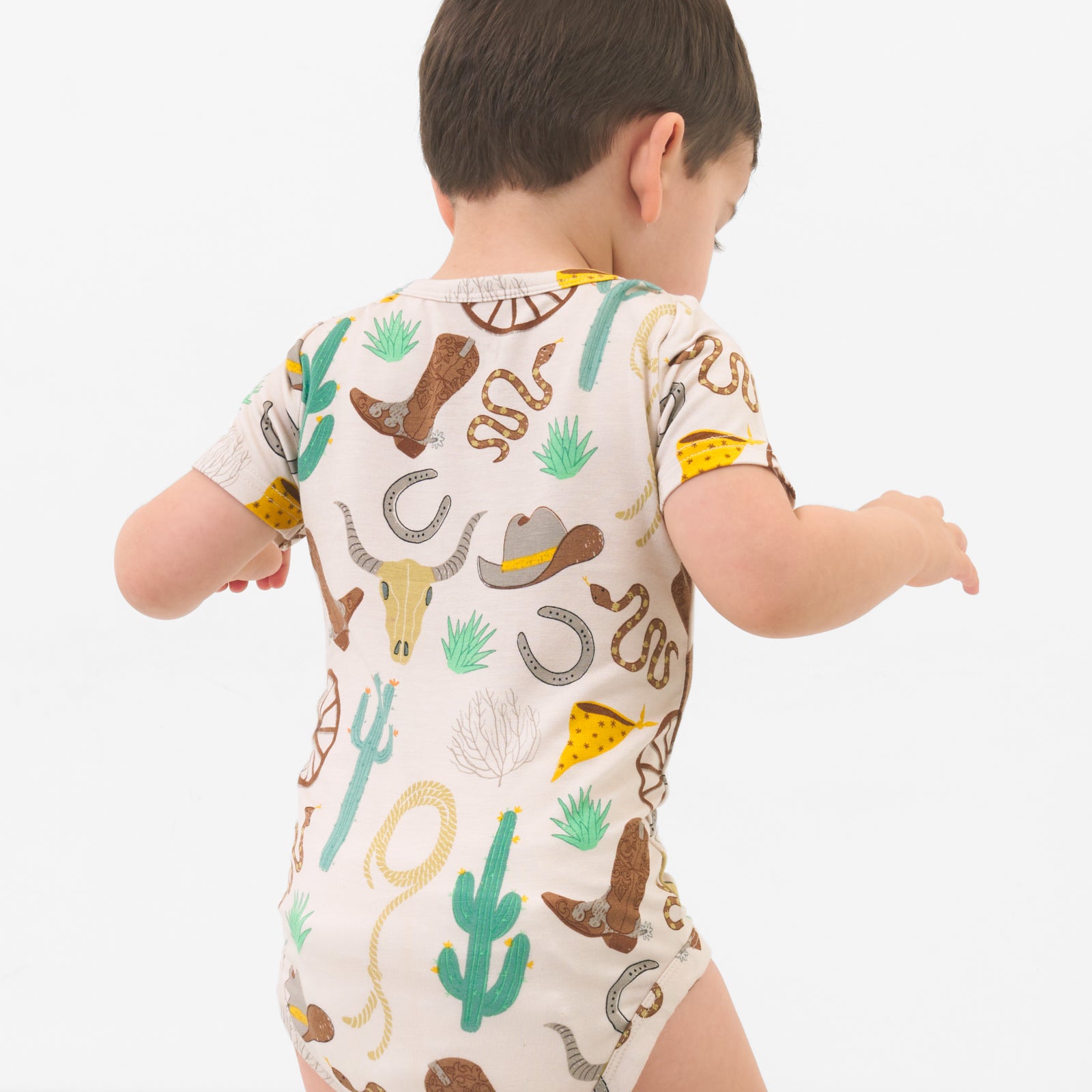 Back view of a child wearing a Caramel Ready to Rodeo Pocket Bodysuit