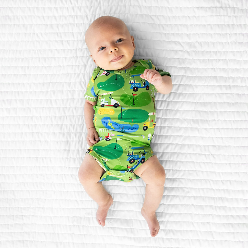 Image of an infant laying on a blanket wearing a Fairway Fun Bodysuit